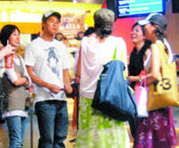 10:27pm  杨佑宁（左二）陪女友（左）排队买电影票，与成群异性说笑。