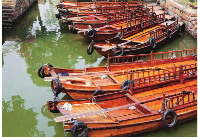 停靠在河边的观光船也是乌镇人出行的交通工具。