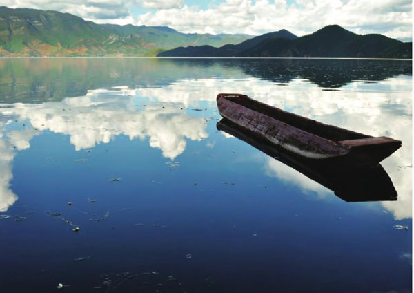 一艘古老空旷的猪槽船静静地泊在湖面，给美丽的泸沽湖增添了一丝丝神秘。