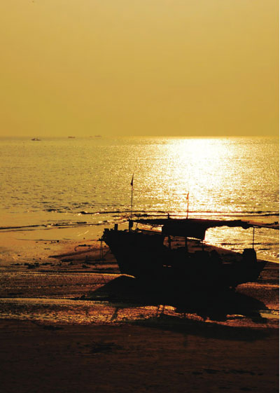一艘小船停在沙滩上，静静地迎接落日黄昏的美丽。
